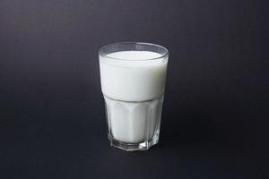 transparentes glas milch auf einem schwarzen foto