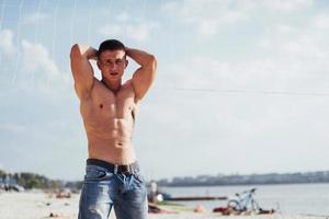 muskulöses männliches modell mit perfektem körper, der in blue jeans aufwirft foto