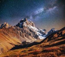 fantastischer Sternenhimmel. Herbstlandschaft und schneebedeckte Gipfel. ma foto