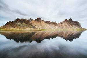 Erstaunliche Berge, die sich bei Sonnenuntergang im Wasser spiegeln. stoksnes, ic foto