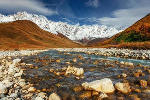 schneebedeckte Berge und lauter Gebirgsfluss. Georgien, Swanetien foto