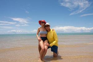 paar, das spaß am strand hat und auf einer sandbank in ponta do corumbau, bahia, brasilien kniet foto