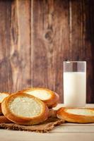 Brötchen mit Hüttenkäse und Glas Milch auf Holzhintergrund. foto