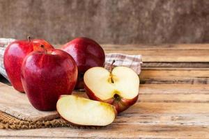 Schneiden Sie roten Apfel auf alten Holztisch
