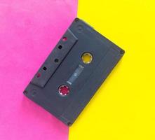 schwarze audiokassette auf einem rosa-gelben kreativen hintergrund foto