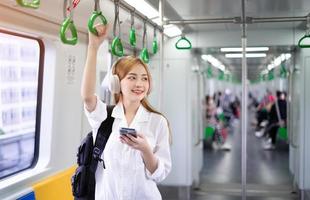 Bild einer jungen Asiatin mit Smartphone in der U-Bahn foto