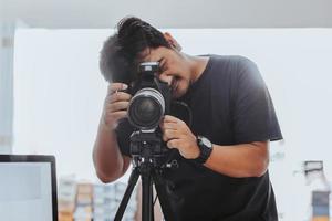 männlicher fotograf, der ein foto mit einem stativ macht