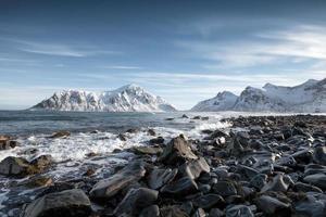 blauer sonnenaufgang der schneebergkette mit wellenschlag an der küste am skagsanden strand foto