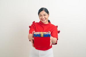 glückliche asiatische frau, die rotes hemd mit geschenkbox auf hand für weihnachtsfest trägt foto