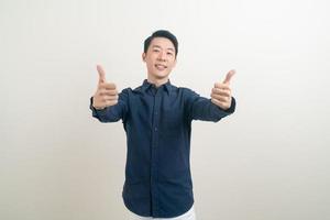 junger asiatischer mann daumen hoch oder ok handzeichen foto