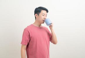 junger asiatischer mann, der kaffeetasse hält foto