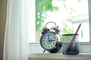 Uhr mit Bleistift am Fenster foto