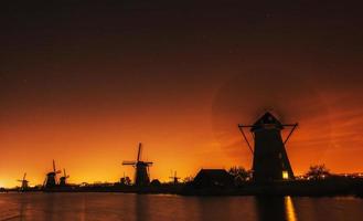 fantastischer orangefarbener Sonnenuntergang Traditioneller holländischer Windmühlenkanal in Fäulnis foto