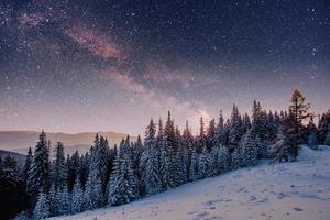 sternenhimmel in der verschneiten winternacht. fantastische Milchstraße foto