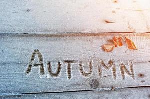 Herbst auf einem hölzernen Hintergrund mit Frost geschrieben foto