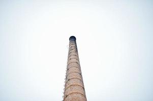 Großer Backsteinturm ohne Rauch gegen nebligen Himmel. foto