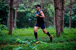 ein mann läufer von trail und athletenfüßen, die sportschuhe für das trailrunning im wald tragen foto