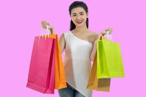 Schönes Mädchen der asiatischen Frauen hält Einkaufstüten und lächelt foto