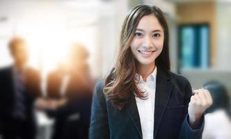 Erfolg und Erfolgskonzept für asiatische Geschäftsfrauen - glückliches Team mit erhobenen Händen, das den Durchbruch und die Errungenschaften feiert