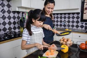 asiatische familien kochen und eltern bringen ihren töchtern das kochen in der küche zu hause bei. familienaktivitäten an feiertagen und glücklich im erholungskonzept foto