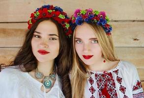zwei junge schöne frauen mit langen haaren in ukrainischen blusen und in einem kränzchen im ethnischen dorf im freien in kiew ukraine foto