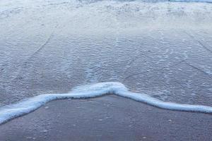 schöne weiße Meereswellen am leeren Strand. foto