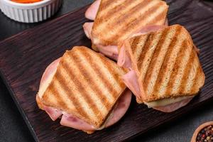 köstlicher frischer Toast vom Grill mit Käse und Schinken. Sandwiches, schneller Snack foto