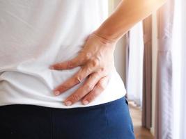 Frau mit Rückenschmerzen und Taillenschmerzen foto