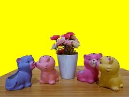 kleine bunte Katzenfiguren aus Plastik gebaut und Blumen auf dem Tisch foto