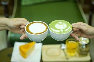 hand und kaffee und heißer grüner tee junge leute lieben es, heiße getränke zu trinken. gesunde kaffee- und getränkekonzepte foto