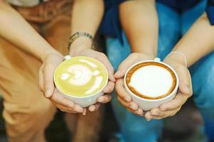 hand und kaffee und heißer grüner tee junge leute lieben es, heiße getränke zu trinken. gesunde kaffee- und getränkekonzepte foto