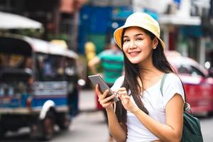 junge asiatische frau, die smartphone an der khaosan road verwendet. foto