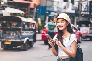 Solo-Frau Sightseeing mit moderner Technologie verwenden Smartphone für Taxi. foto