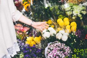 asiatische frau kauft eine blume im blumenladen foto