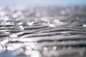 Funkelnde nasse Strandsandschicht foto