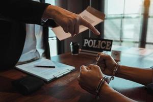 Der Polizist zeigte die Handschellen und hielt die Dokumente fest, um den Angeklagten in einem Betrugsfall festzunehmen. foto