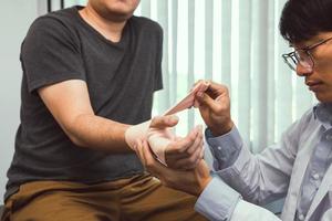 asiatische physiotherapeuten untersuchen die ergebnisse von handgelenkoperationen von patienten. foto