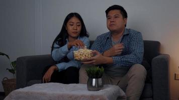 asiatische Paare schauen sich am Wochenende nachts Filme im Fernsehen an. foto