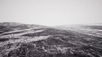 Steine im Schnee am Berg im Sommer foto