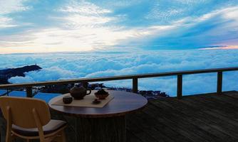 Keramik-Teeset und trockenes Teeblatt auf einem Holztisch und Stuhl auf dem Balkon oder der Terrasse aus Holz. Berg mit morgendlichem Nebelmeer und Sonnenschein. heißer tee auf die bergatmosphäre. 3D-Rendering foto