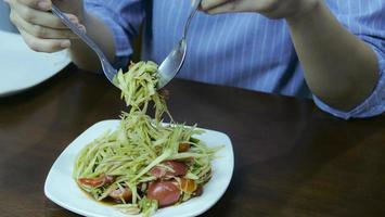 Papaya Salat. hausmannskost in der küche das beliebteste essen in thailand ist scharf, sauer, lecker. Hauptzutaten sind rohe Papaya, Zitrone, Tomate, Knoblauch, Chili foto