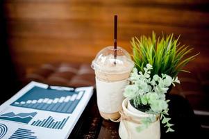 oberer schreibtisch im arbeitsbereich mit laptop-arbeitsblatt und kaffee und es gibt platz für kopien. foto