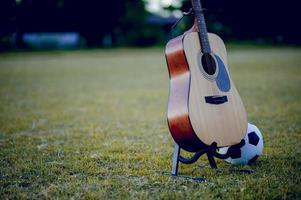 Gitarre und Fußball werden in grüne Rasenflächen gestellt. Musik- und Sportideen und es gibt einen Kopierraum. foto