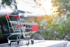 Online-Shopping - Einkaufswagen oder Trolley auf einer Laptop-Tastatur. Einkaufsservice im Online-Web. foto