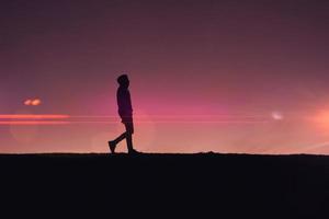 Mann-Silhouette-Trekking in den Bergen mit einem wunderschönen Sonnenuntergang foto