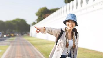 glückliches Lächeln junge erwachsene asiatische Frau Reisenden tragen blauen Hut und Rucksack im Freien am Tag. foto