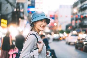 junger erwachsener asiatischer frauenreisenderrucksack, der im stadtlebensstil chinatown straßenlebensmittel mit bokeh hintergrund reist. foto