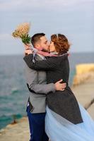 Hochzeitsfotosession eines Paares an der Küste. blaues hochzeitskleid an der braut. foto