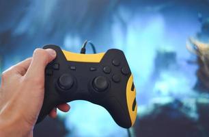 Gamer- und Guy-Controller mit Gamepad-Joystick in der Hand, der Spiele spielt und Videos im Fernsehen oder auf der Computerspielkonsole ansieht - der Junge, der Hobby-spielerischer Genuss, Spaß und Unterhaltung hält foto