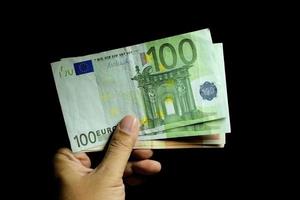 männliche hand, die eurogeldbanknoten hält foto